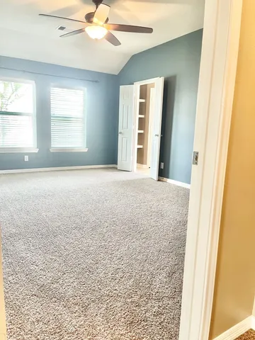 an empty room with a window and a ceiling fan