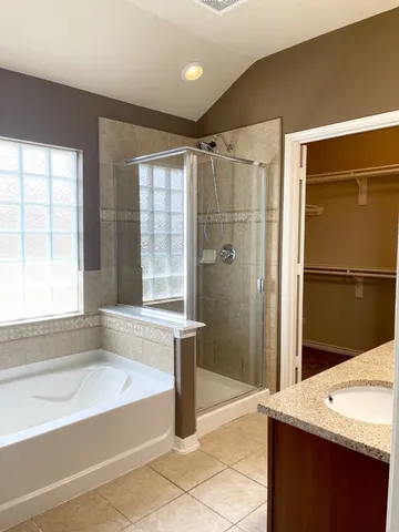 a spacious bathroom with a granite countertop sink and a mirror