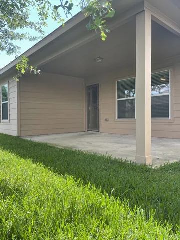 a view of a backyard with large trees and wooden fence