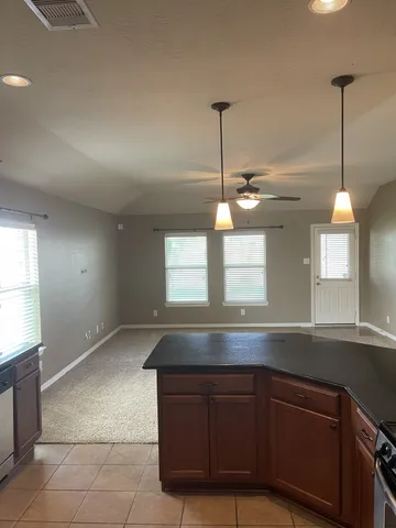 a large kitchen with kitchen island a counter top space a sink stainless steel appliances and cabinets