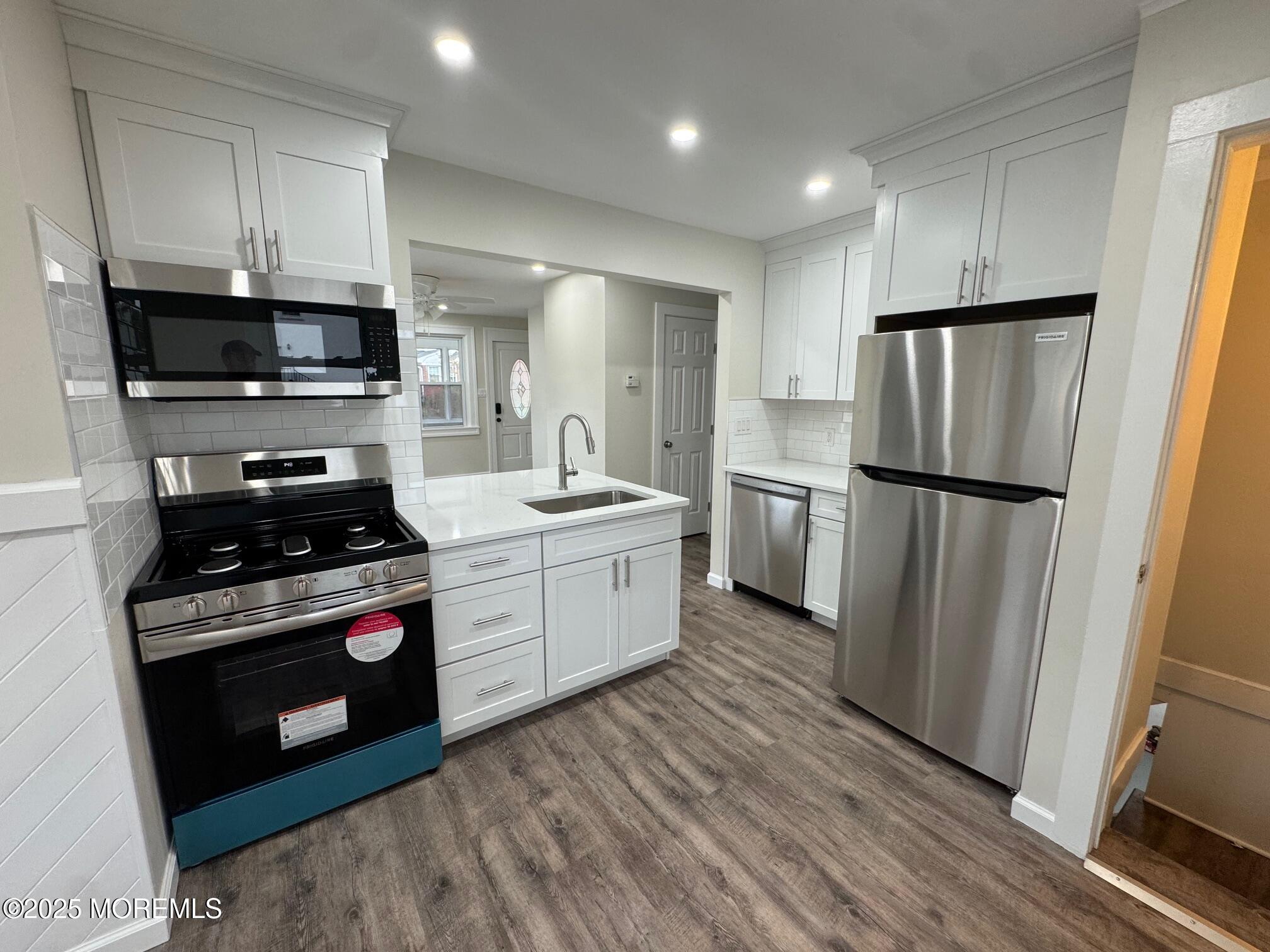 11 Washington Avenue, Unit 1 Leonardo, NJ 07737 - Photo 12 of 23 a kitchen with a refrigerator stove and wooden cabinets
