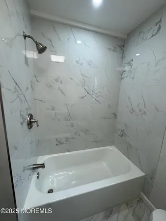 a bath tub sitting next to a white sink and vanity