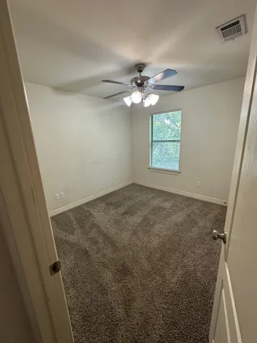 en empty room with windows and fan