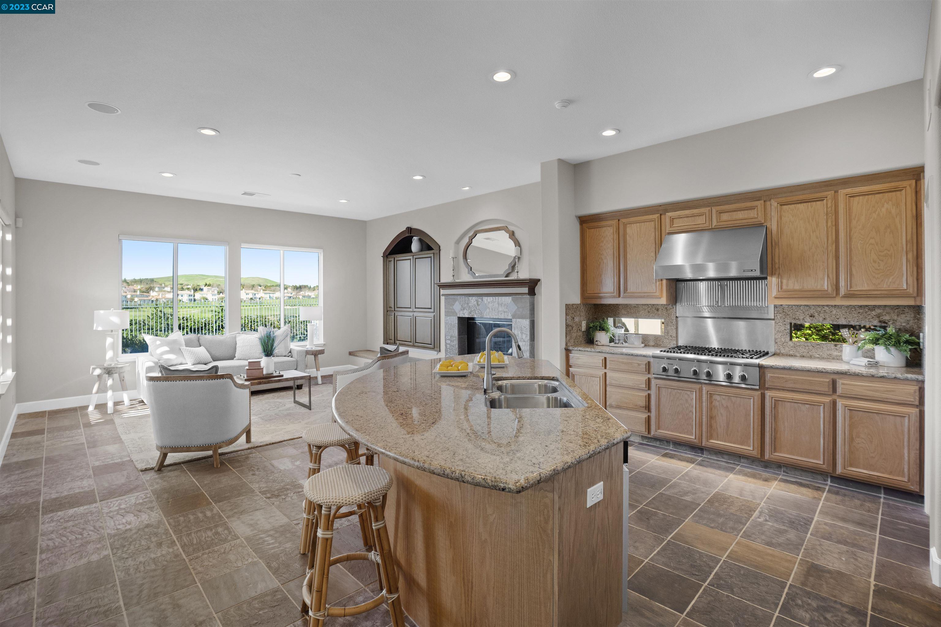 9548 Velvetleaf Circle San Ramon, CA 94582 - Photo 2 of 8 a kitchen with kitchen island granite countertop a stove a sink a dining table and chairs with wooden floor