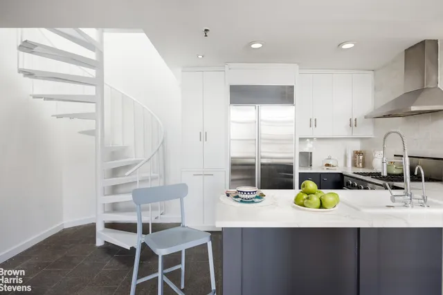 a kitchen with a sink cabinets and wooden floor