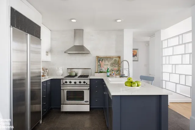 a kitchen with stainless steel appliances a stove a refrigerator and a window
