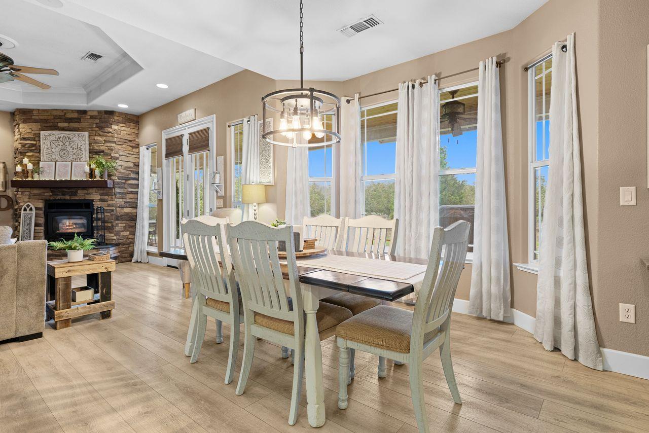 3302 Bear River Drive Rio Oso, CA 95674 - Photo 13 of 50 a dining room with wooden floor a chandelier a wooden table and chairs