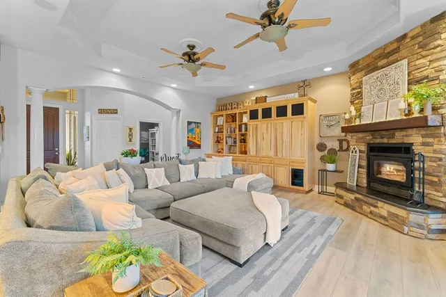 a kitchen with a stove a sink a kitchen island with chairs and wooden cabinets