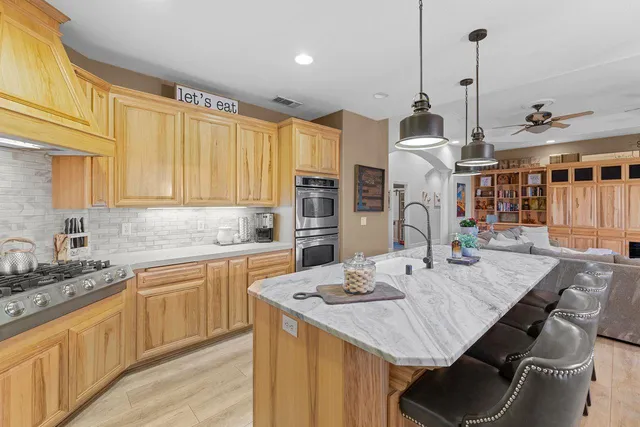 a kitchen with stainless steel appliances granite countertop a sink a stove and cabinets