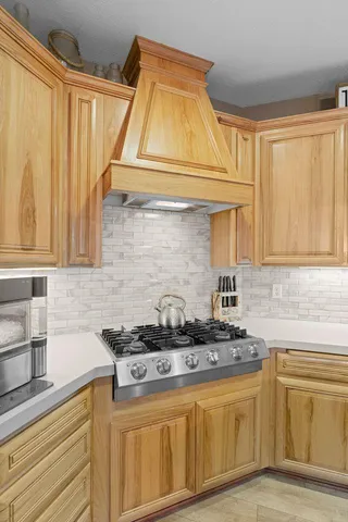 a kitchen with granite countertop a table chairs stainless steel appliances and wooden floor
