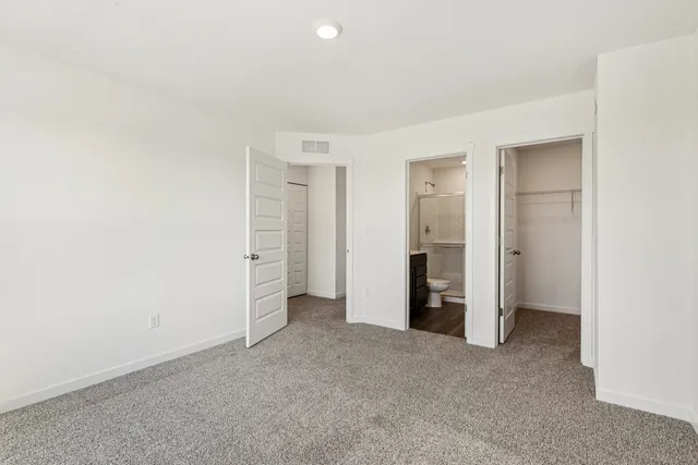 an empty room with closet and a bathroom