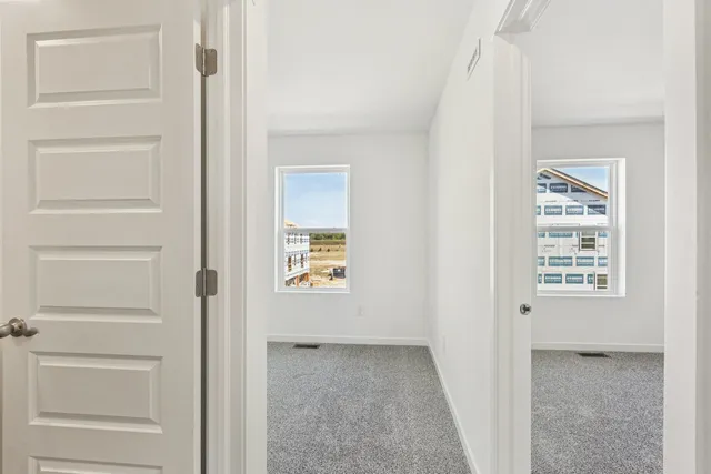 a view of hallway with closet and a window