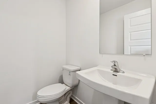 a white toilet sitting next to a bathroom sink