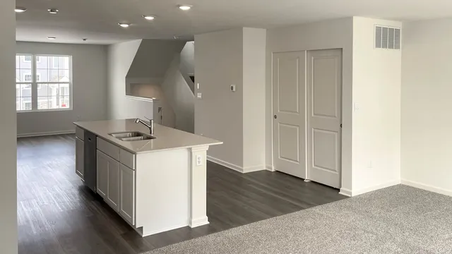 a kitchen with kitchen island white cabinets and wooden floor