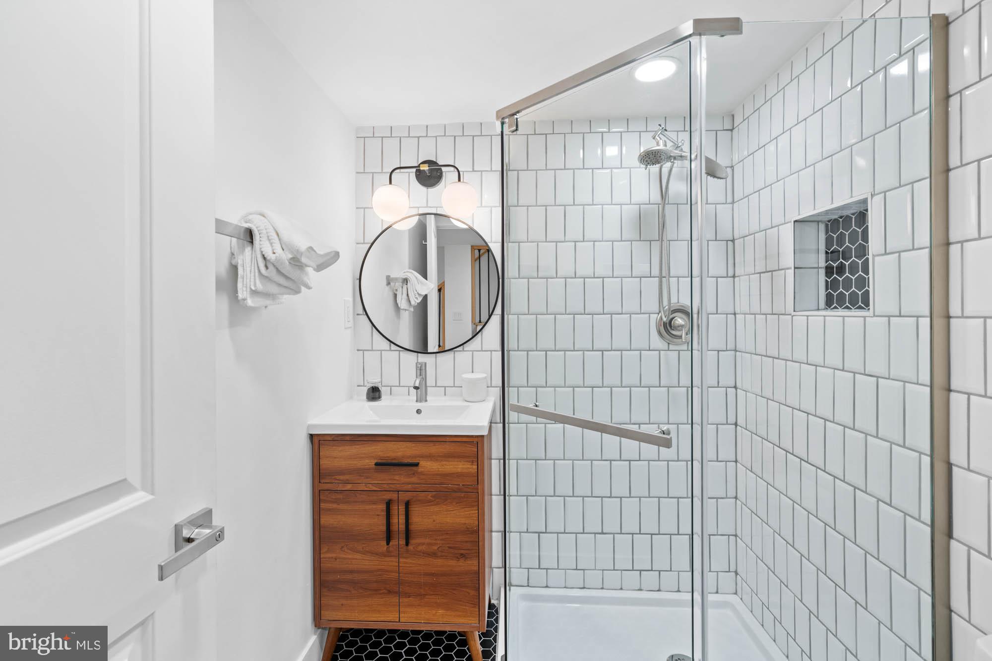 1458 Howard Road Southeast Washington, DC 20020 - Photo 38 of 49 a bathroom with a sink a mirror and shower