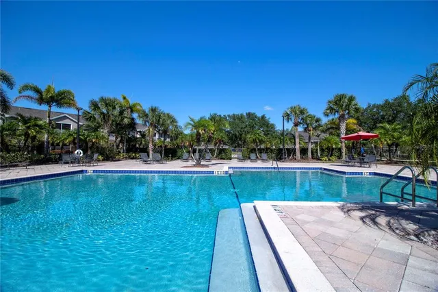 a view of a swimming pool with a yard and a fountain