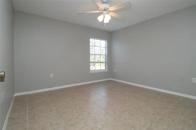 an empty room with a window and a fan