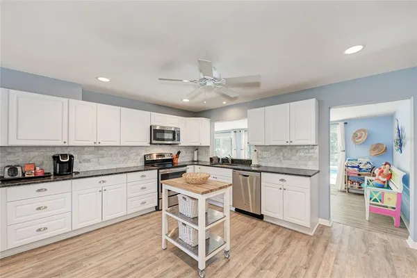 a kitchen with a center island wooden floor and stainless steel appliances