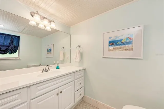 a bathroom with a double vanity sink a toilet and a mirror