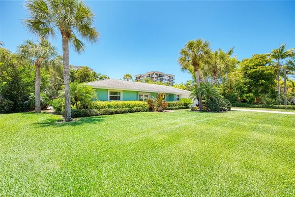 a front view of a house with a yard and trees