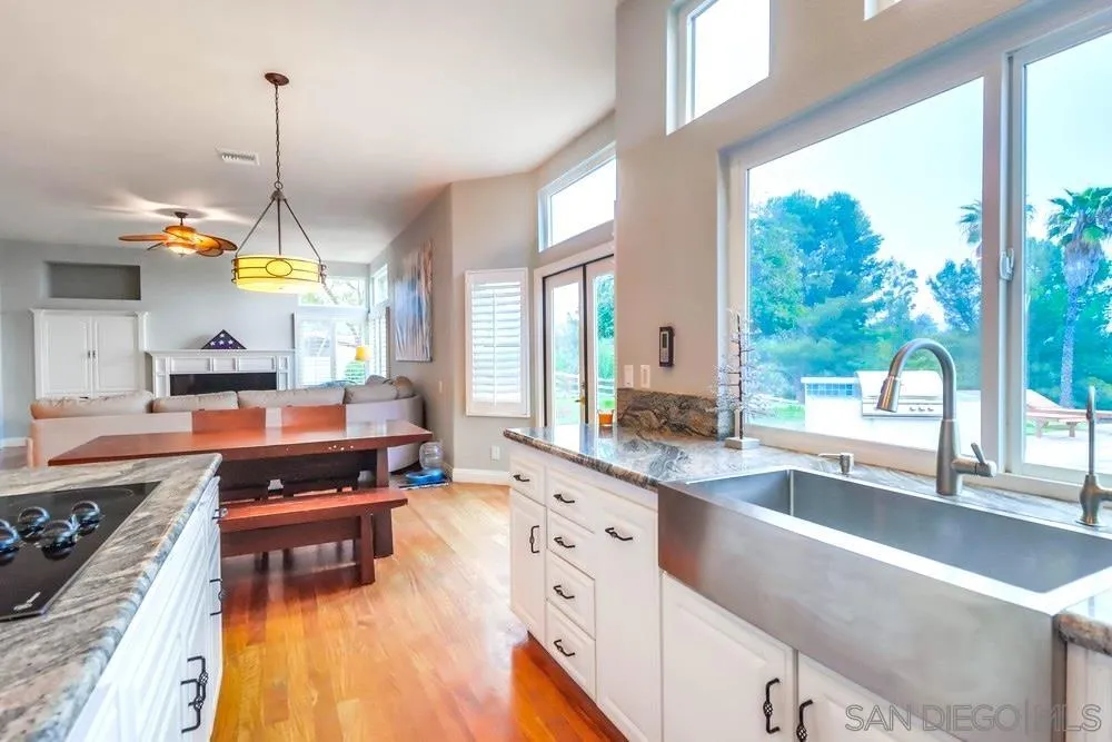 3646 Hidden Ridge Road Jamul, CA 91935 - Photo 16 of 43 a kitchen with kitchen island granite countertop a stove a sink and a living room view