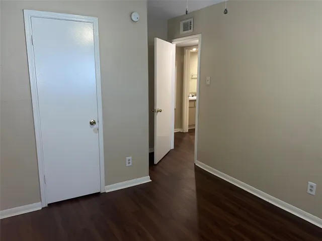 an empty room with wooden floor and closet