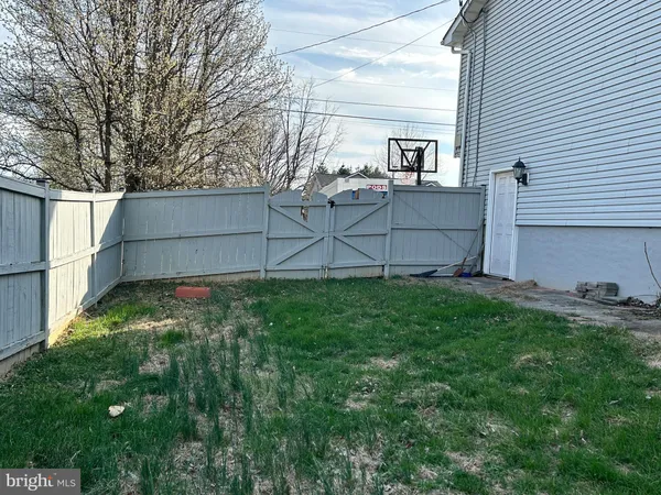 a view of backyard with barbeque grill and wooden fence