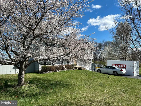 a front view of a house with a yard and tree s