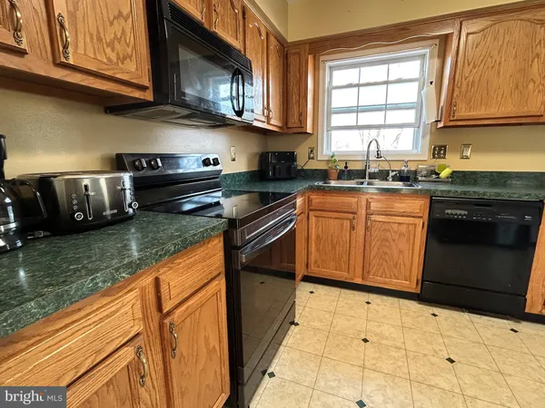 a kitchen with stainless steel appliances granite countertop a stove sink and cabinets