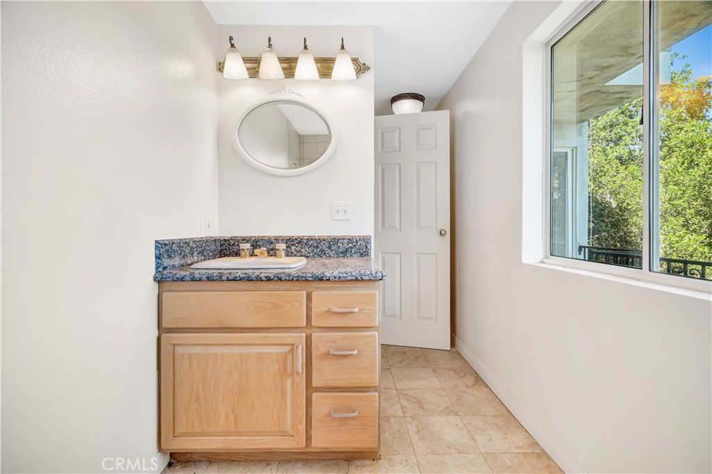 22011 Callado Way Topanga, CA 90290 - Photo 40 of 49 a bathroom with a granite countertop sink and a mirror
