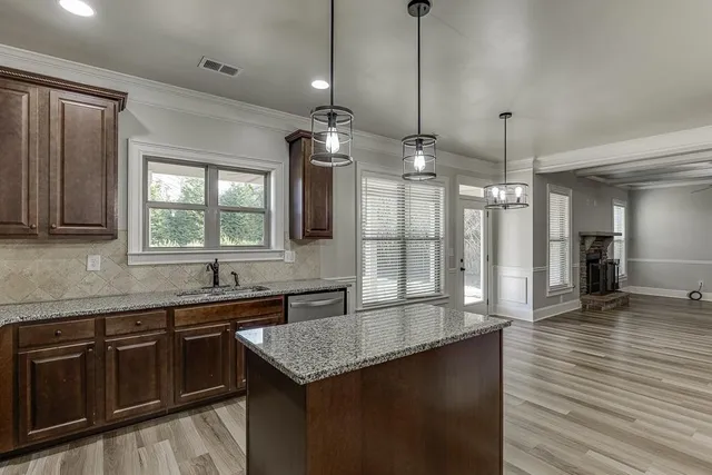 a kitchen with granite countertop a sink and cabinets