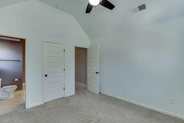 an empty room with closet and windows