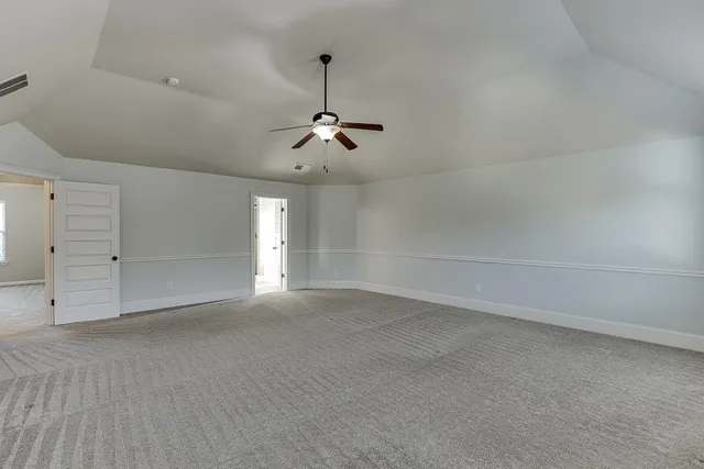 en empty room with windows and ceiling fan