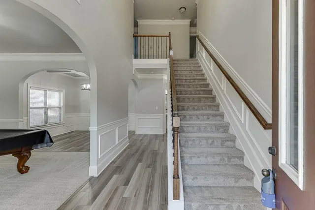 a view of a hallway with wooden floor and staircase