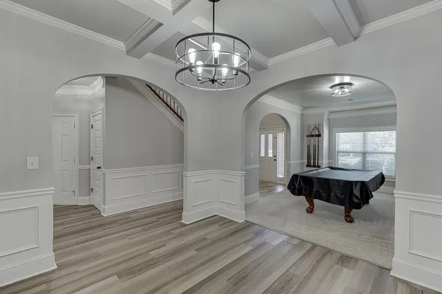 an empty room with wooden floor table and chairs