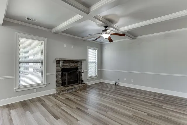 wooden floor fireplace and windows in an empty room