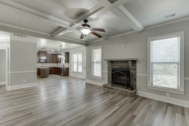 a view of an empty room with a fireplace and a window