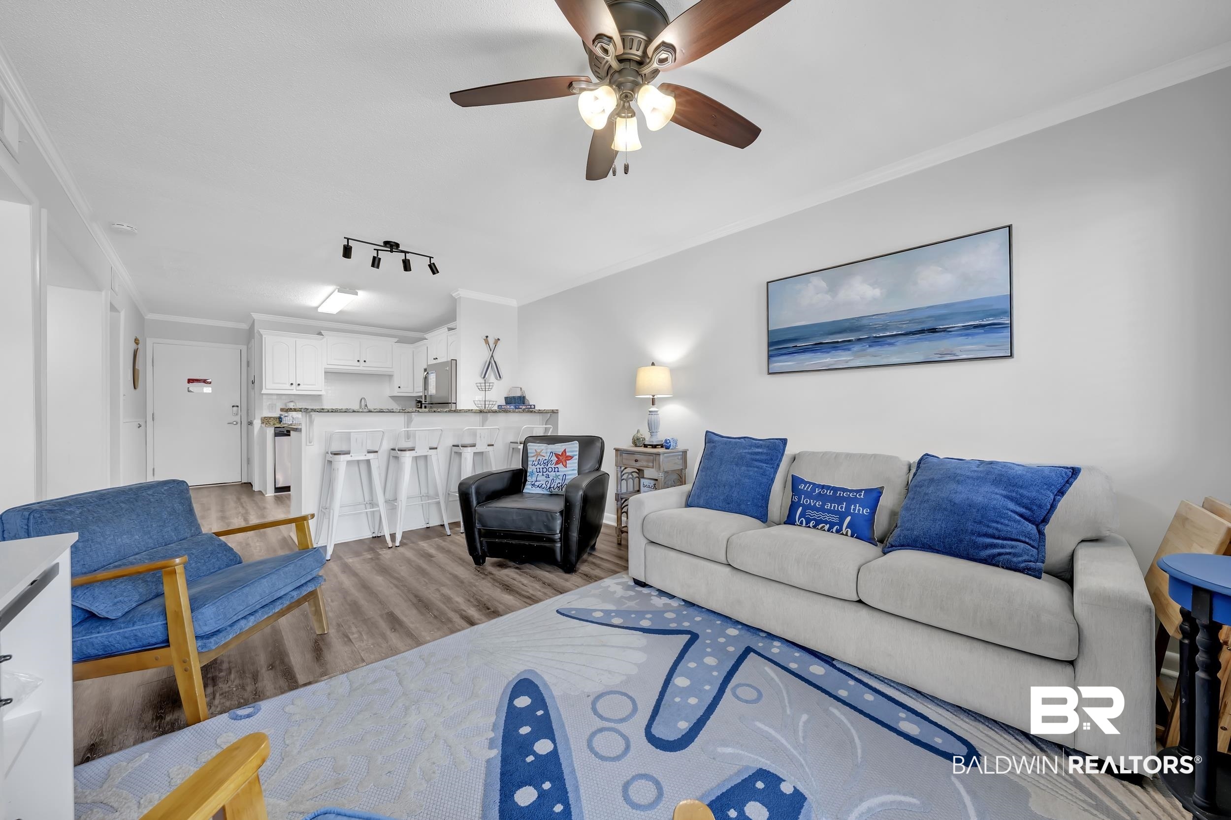 400 Plantation Road, Unit 2118 Gulf Shores, AL 36542 - Photo 3 of 59 Open-concept living area featuring wood-finish flooring, a ceiling fan with integrated lighting, and crown molding