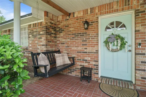 a brick building with a bench and a potted plant