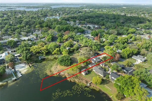 an aerial view of residential houses with outdoor space and trees
