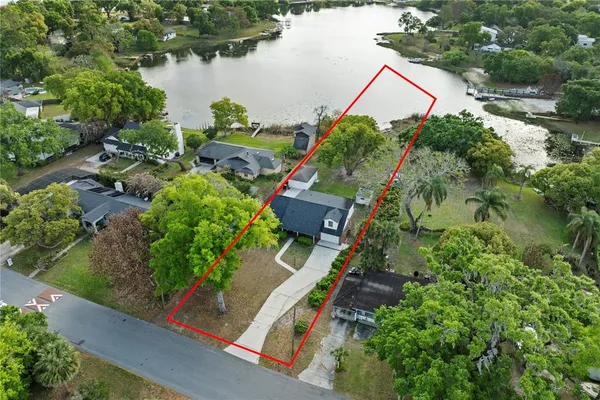 an aerial view of a house with a yard and lake view