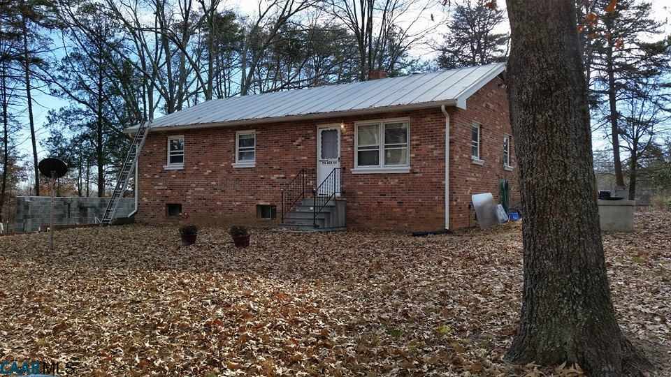 a view of a brick house next to a large tree