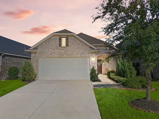 a front view of a house with a yard and trees