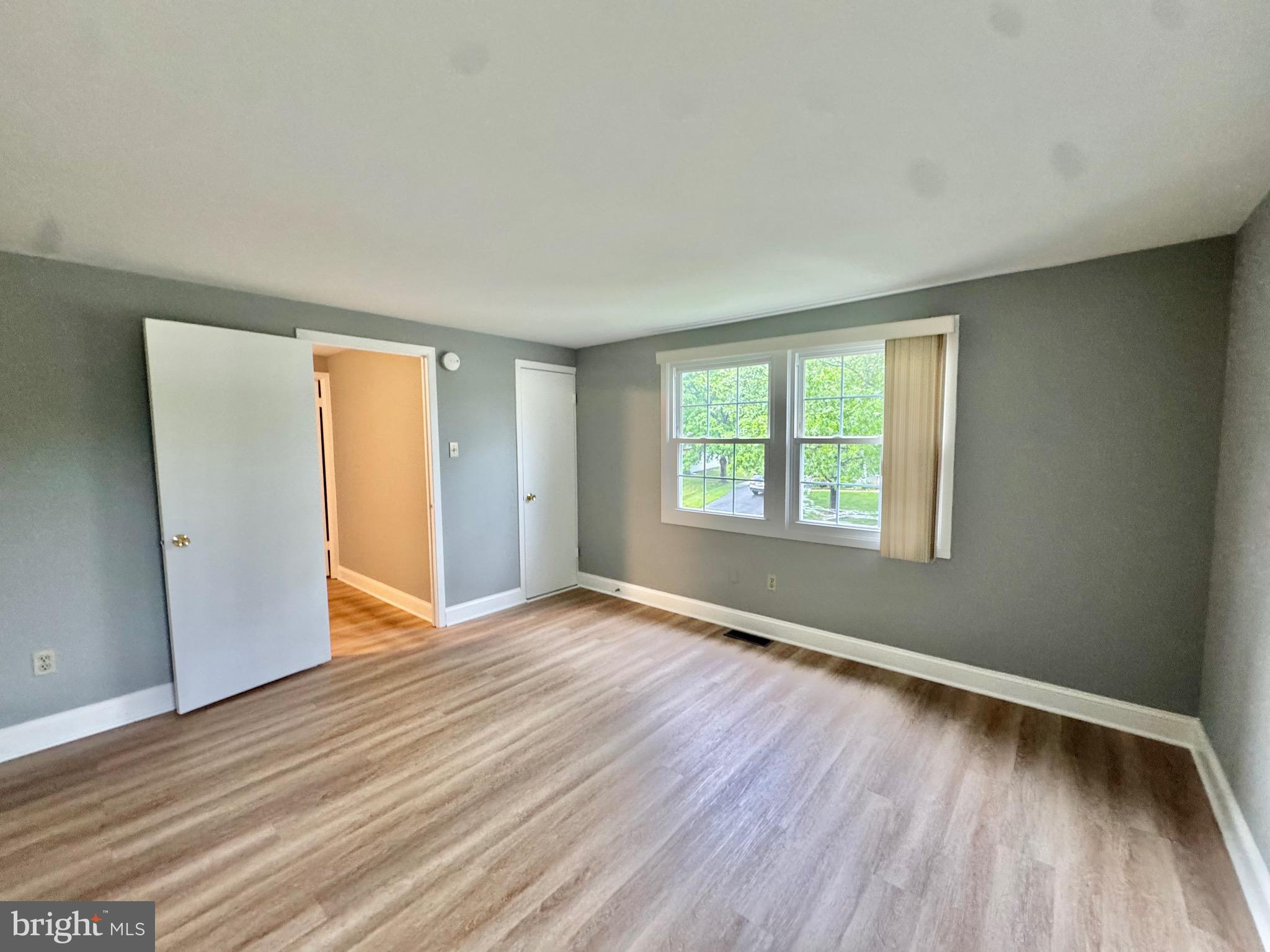 4908 Rocky Spring Lane Bowie, MD 20715 - Photo 18 of 36 an empty room with wooden floor and windows