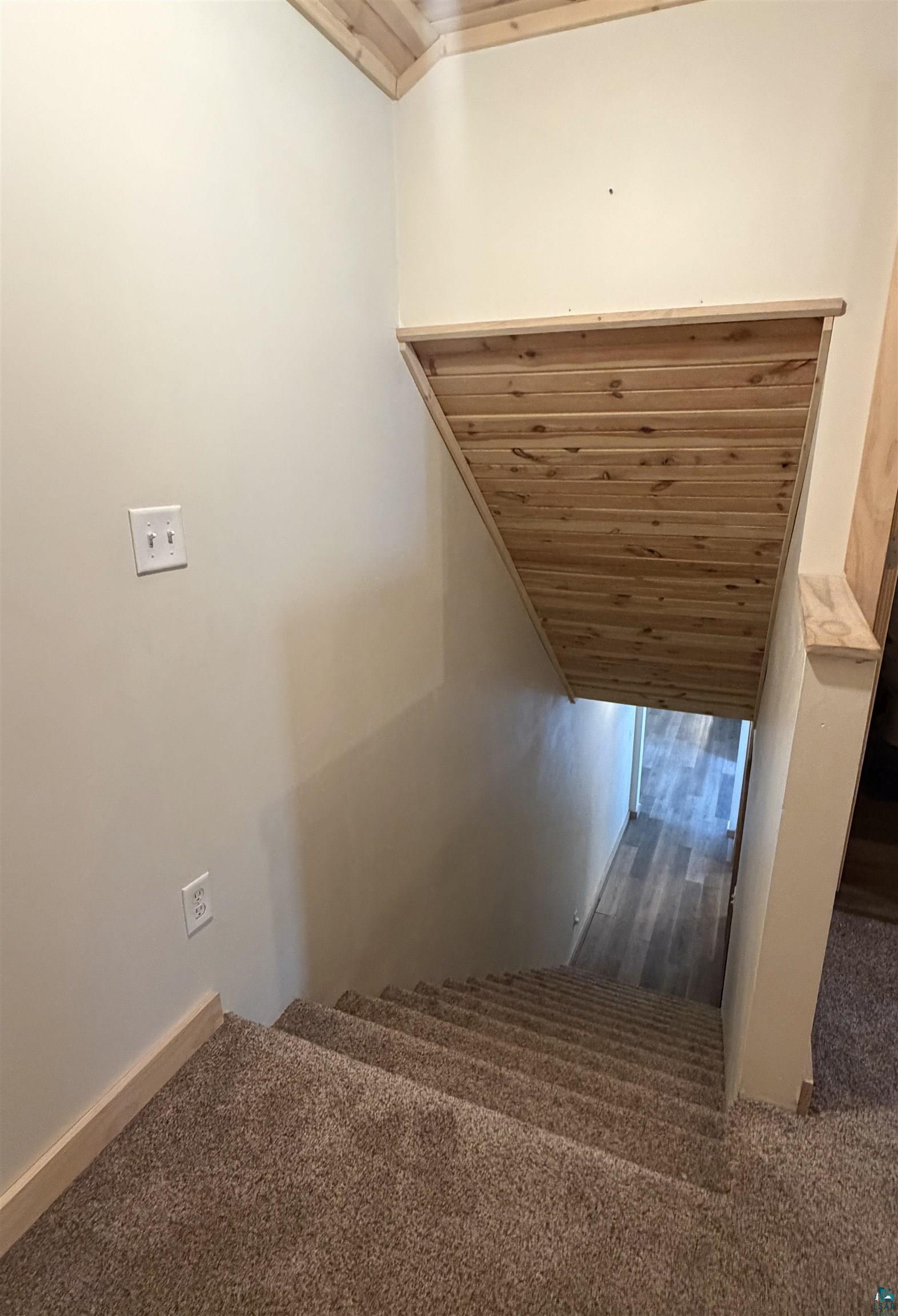 5274 Marble Lake Road Two Harbors, MN 55616 - Photo 46 of 79 Carpeted staircase with light wood-finish wainscoting and coordinating ceiling trim