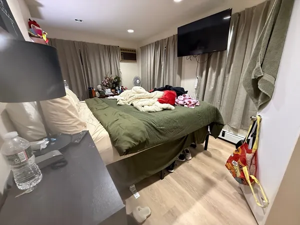 a bedroom with bed and a flat tv screen