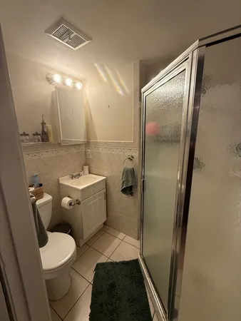 a bathroom with a sink a toilet a mirror and shower