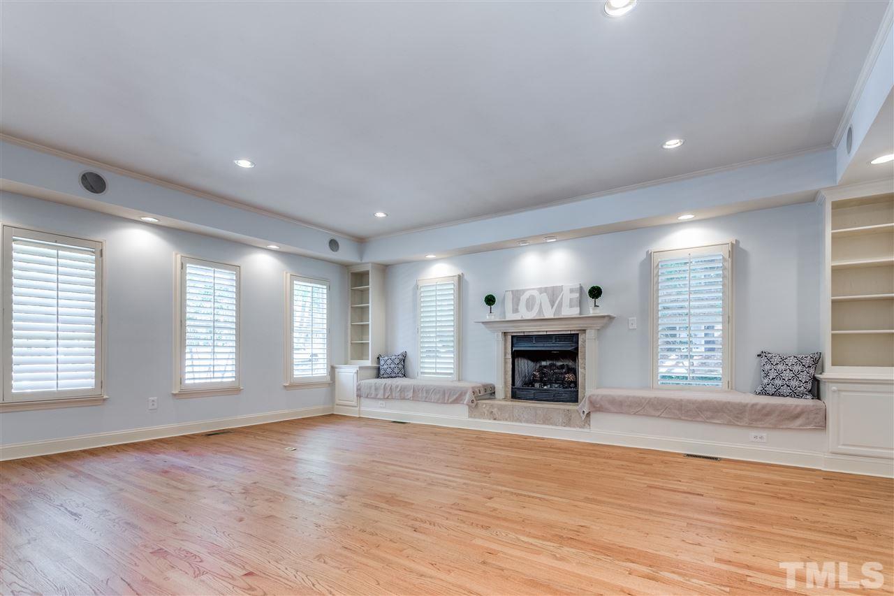 2915 Buckingham Road Durham, NC 27707 - Photo 9 of 25 an empty room with windows fireplace and wooden floor