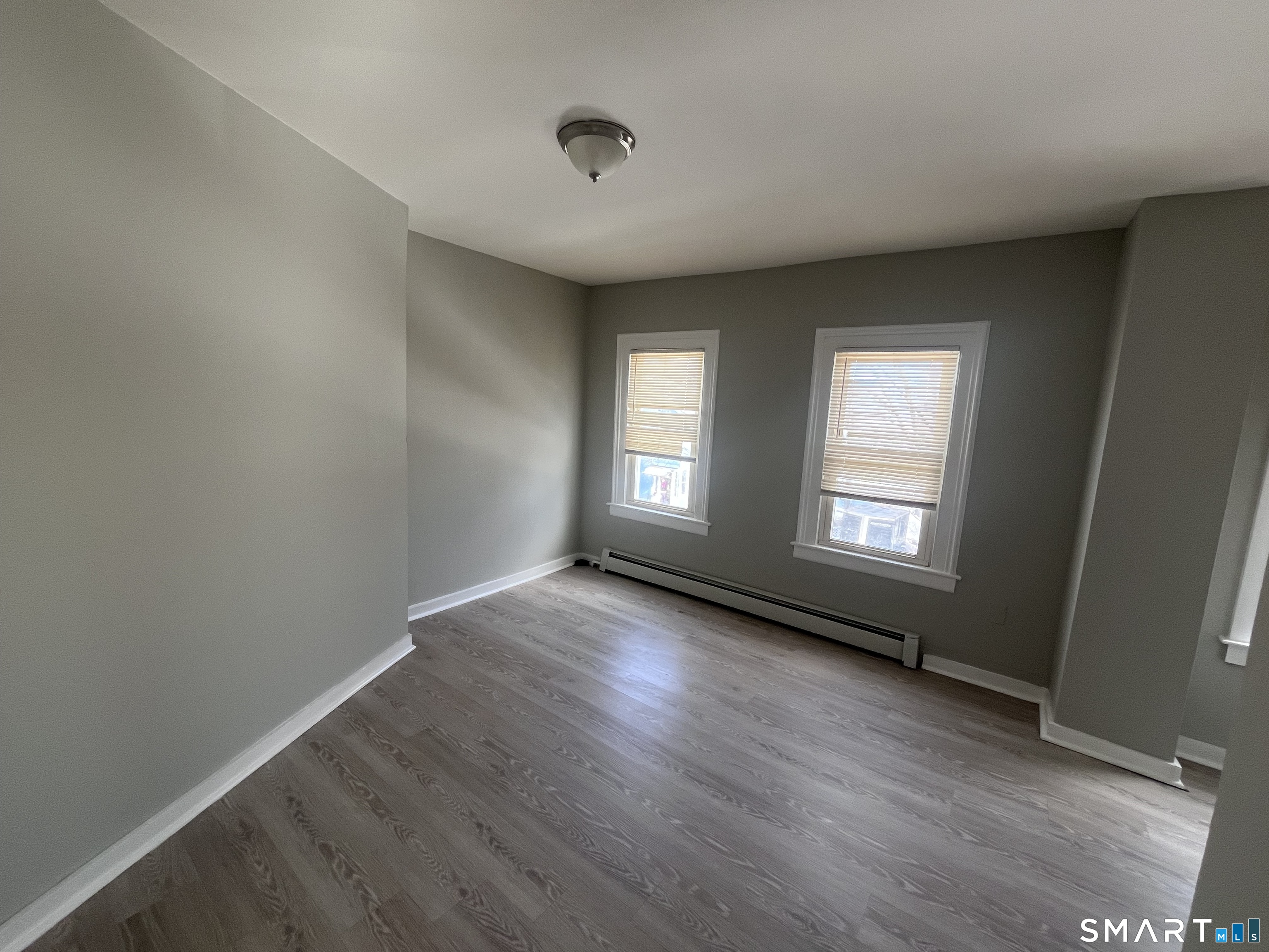 144 Clark Street New Britain, CT 06051 - Photo 11 of 14 an empty room with wooden floor and windows