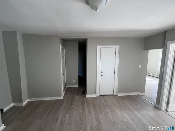 an empty room with wooden floor and entrance